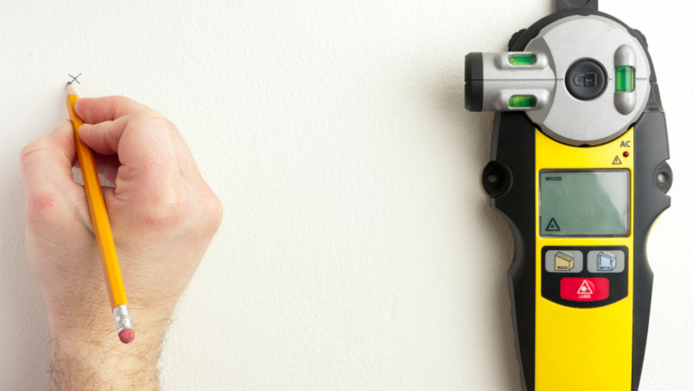 laser stud finder against a white wall