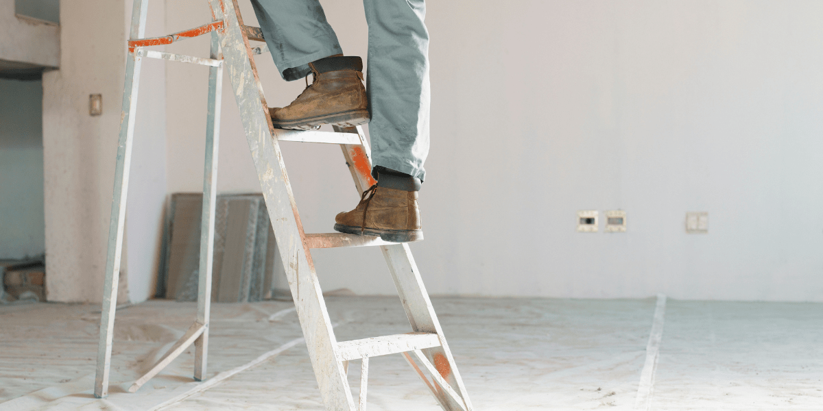 picture of a carpenters shoes stepping up a ladder