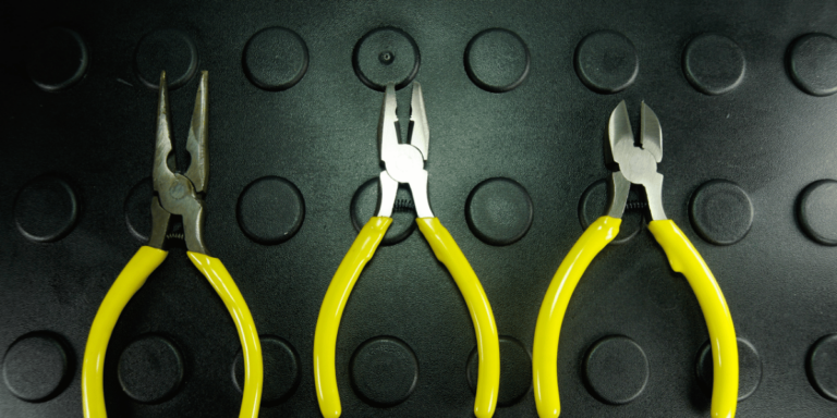 3 yellow-handled pliers against a green backdrop