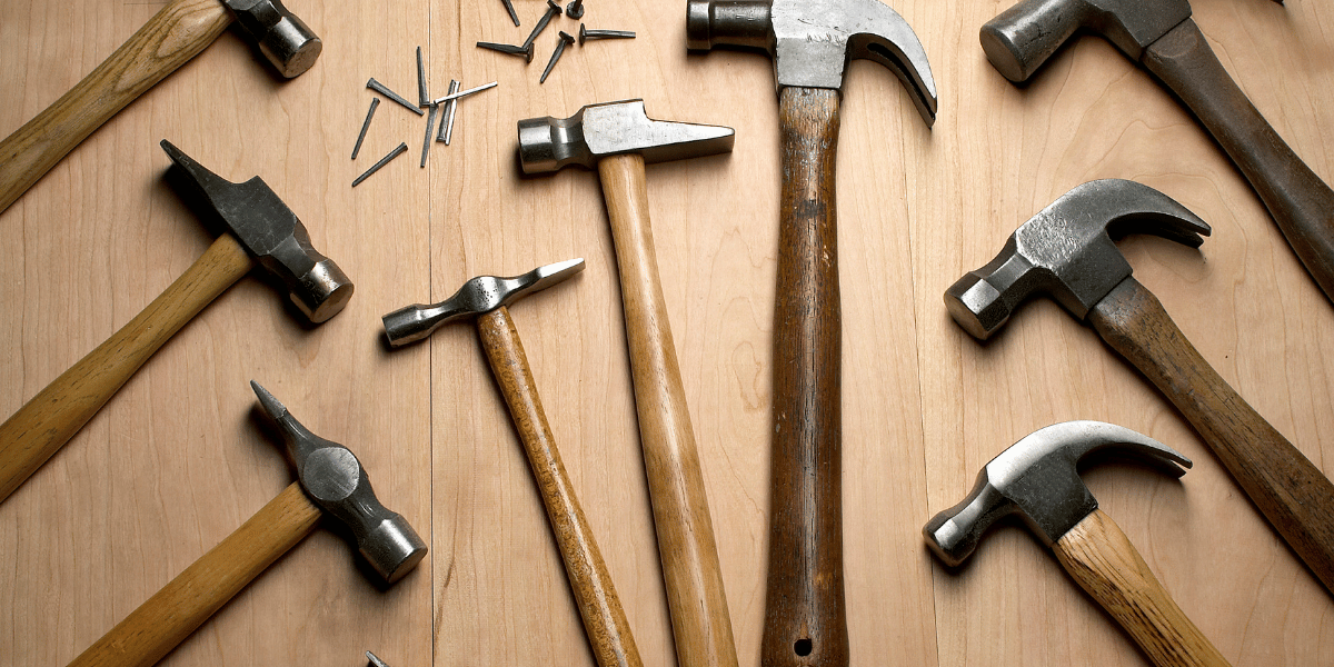 a selection of hammers laying flat on a wooden table