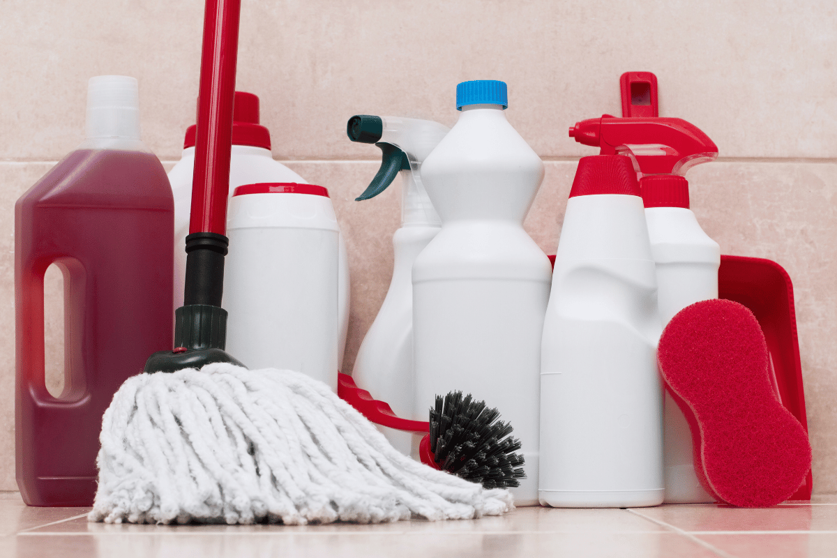 collection of bathroom cleaning supplies against a tile wall